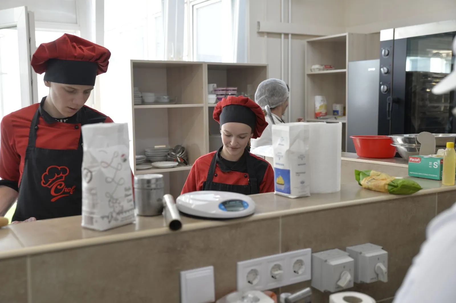 Jeunes en formation dans une cuisine professionnelle, en tenue de travail
