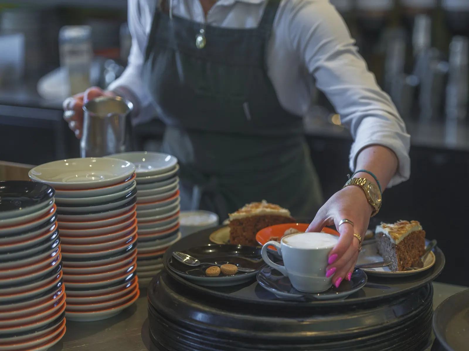 Barista qui sert un café et une part de gâteau dans un café animé